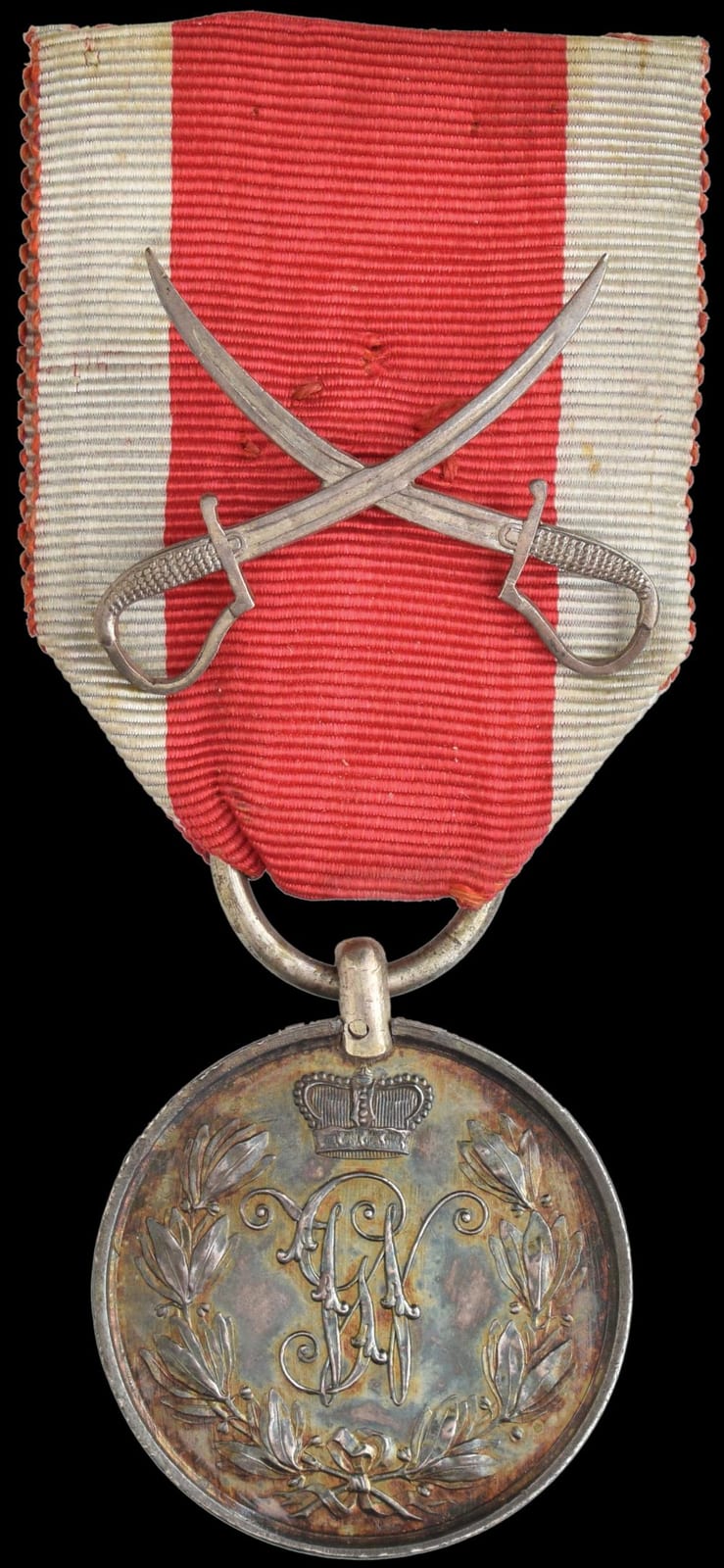 Circular military bravery medal on a red-and-white striped ribbon with crossed silver sabres.