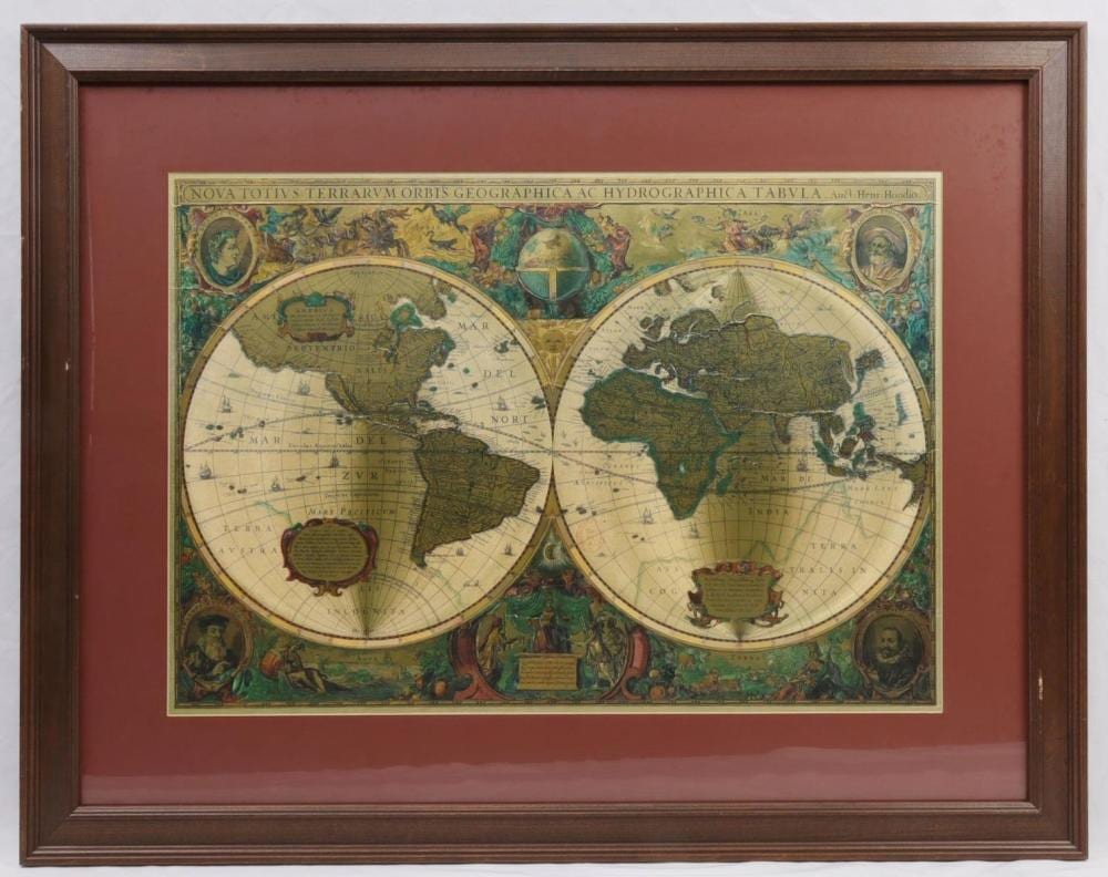 Framed world map print showing two circular hemispheres with decorative figures around the edges.
