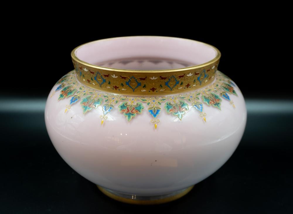 White glass vase with gold rim and colorful floral scrollwork decoration on the body.