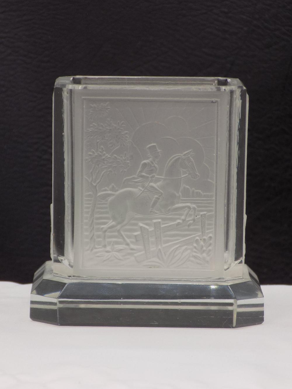 Clear glass toothpick holder with a raised scene of mounted riders on a horse-drawn landscape.