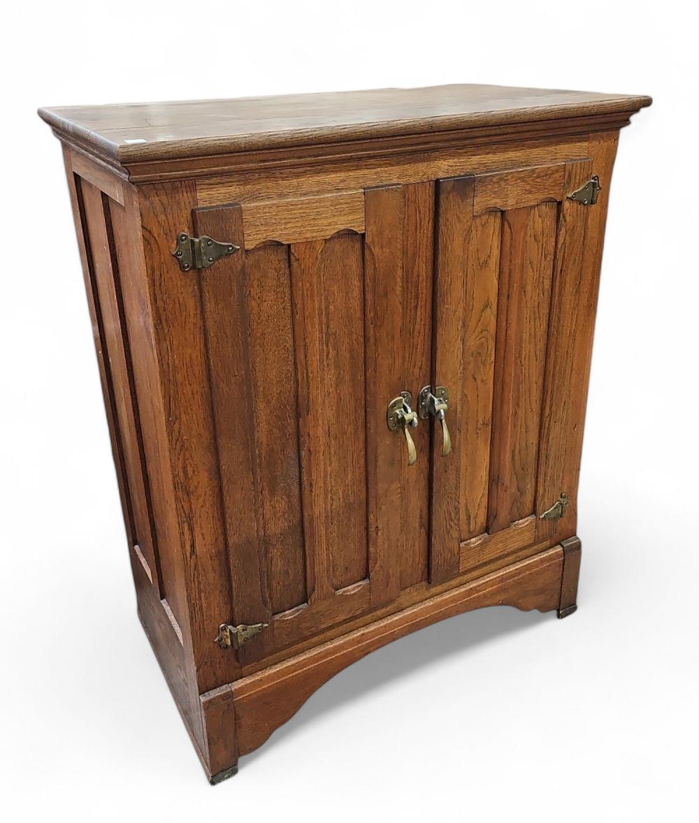 Wooden cabinet-style ice box with a hinged front door, metal latches, and paneled sides.