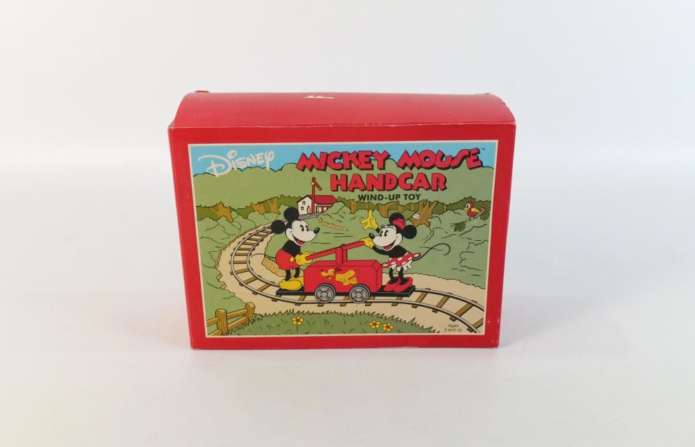 Red boxed wind-up toy featuring Mickey Mouse and Minnie Mouse riding a handcar on tracks.