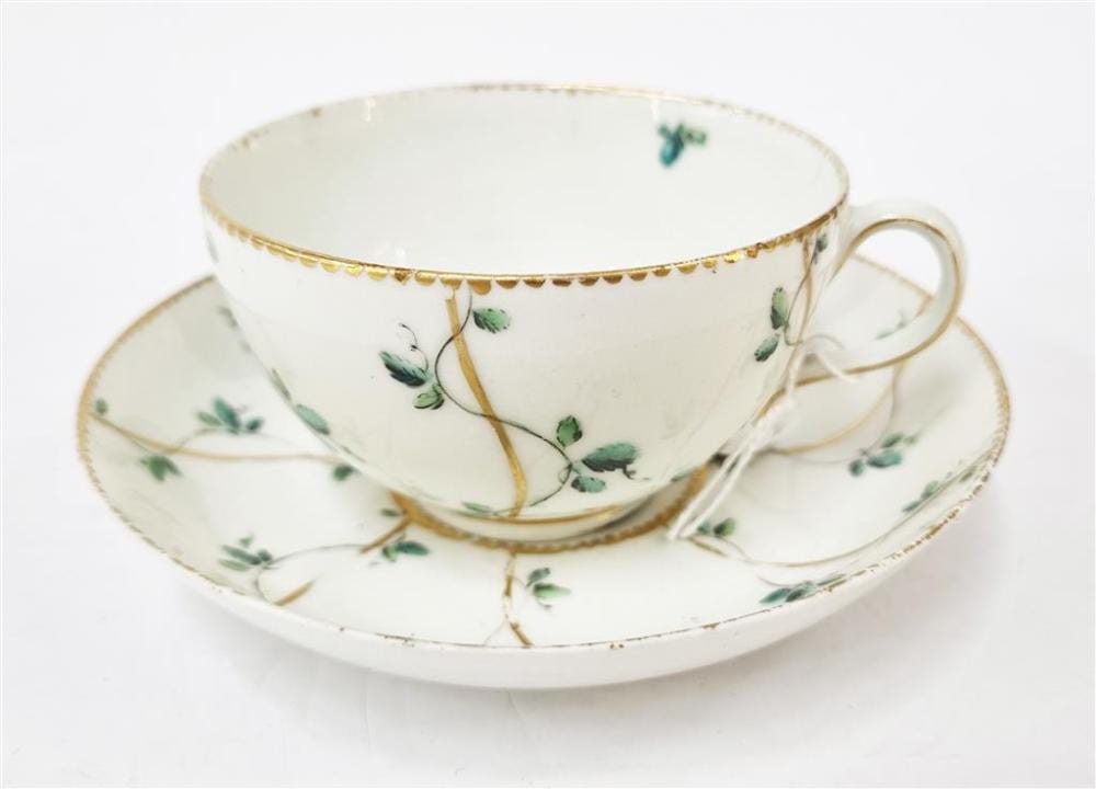 AN 18TH CENTURY CHELSEA DERBY PORCELAIN TEA CUP AND SAUCER, painted with green sprigs and gilt work, painted gilt mark to base, cir... sold by Raffan Kelaher & Thomas, lot 305 — auction record photograph