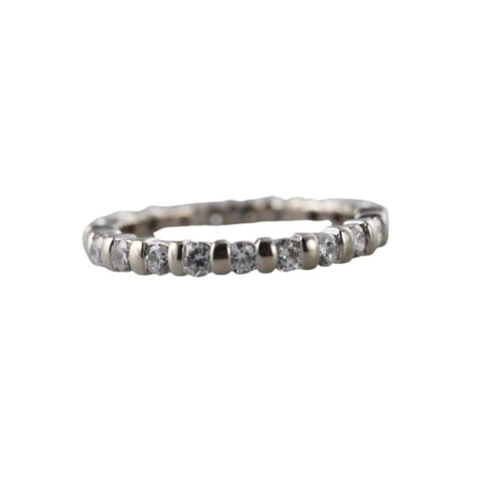 Close-up of a silver-colored eternity wedding band ring with a row of small round diamonds across the top.