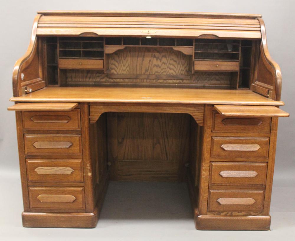 Furniture: antique oak s-roll top desk: a solid oak roll top with /batwing/ swing out sides @top, fitted interior; raised panels top & bottom of back & sides; three drawers each side with pull out surfaces; comes with key/original lock; old natural r sold by Roan Inc. Auctioneers & Appraisers, lot 505 — auction record photograph