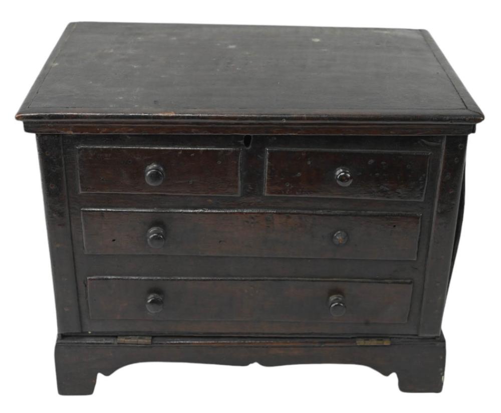 Dark wooden sewing box with a flat hinged lid and multiple front drawers with round knobs