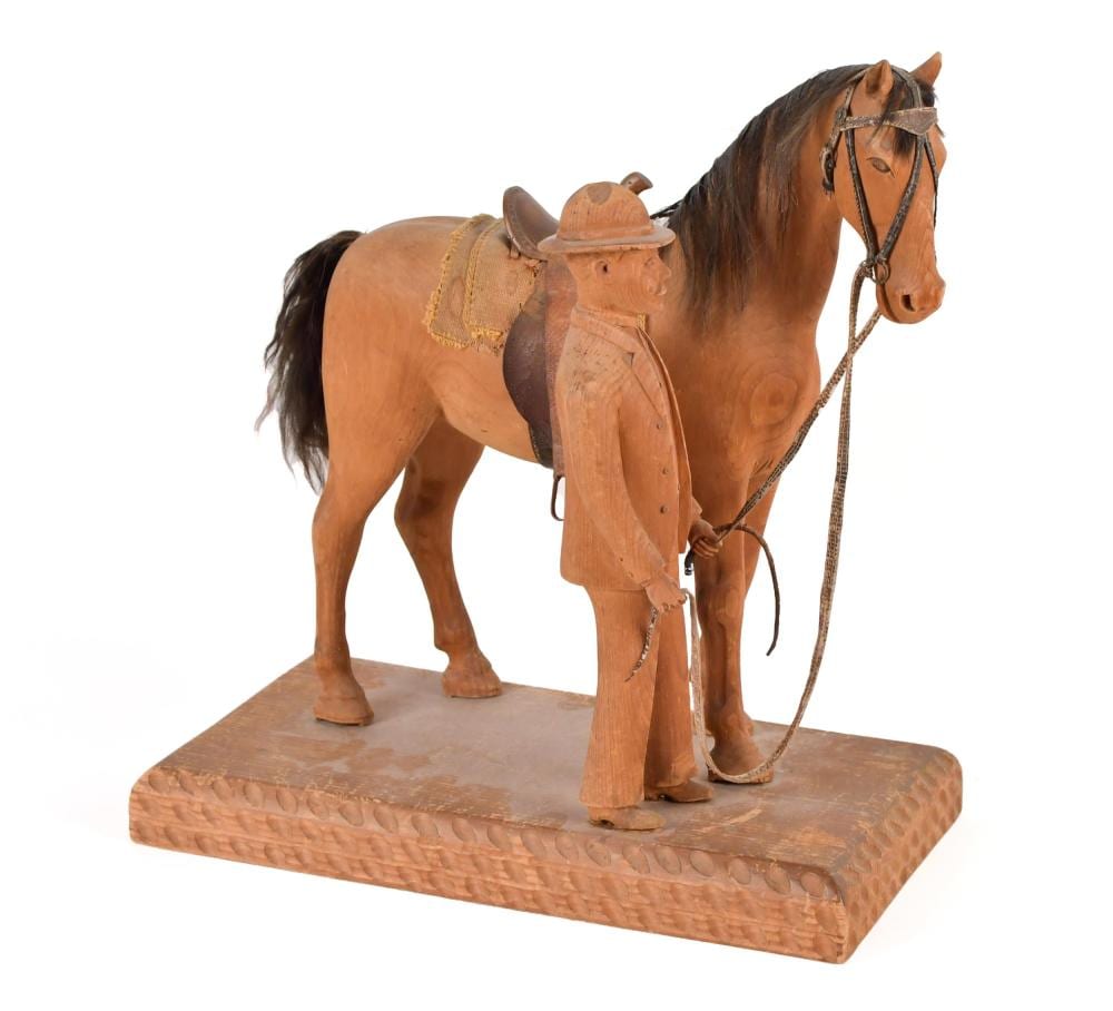 Carved wooden folk art figure of a man in a hat holding a reins, posed beside or on a carved horse.