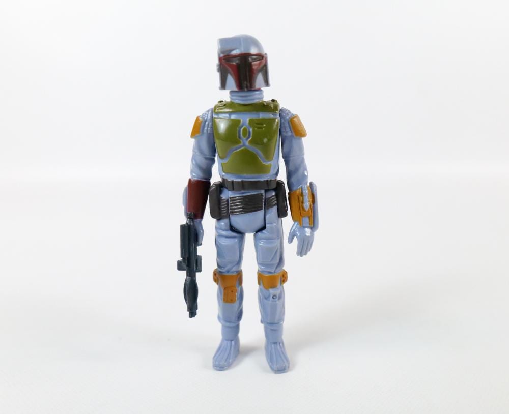 Front view of a small sci-fi action figure in blue armor with green chest armor and a red helmet.