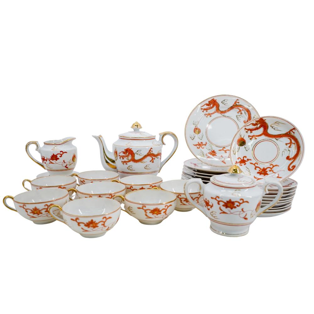 White porcelain tea set with orange-red dragon and cloud decorations, including teapot, small teapot, cups, saucers, and plates.