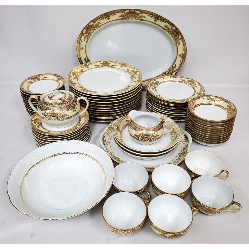 Noritake-style white porcelain dinnerware set with gold ornate floral trim, including plates, bowls, cups and saucers, and creamers