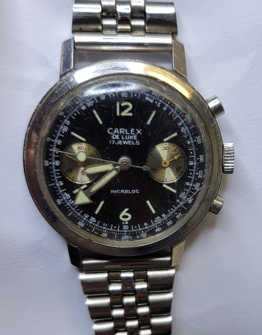 Vintage wristwatch with black dial and gold subdials, date/markings around the bezel, steel bracelet and crown.
