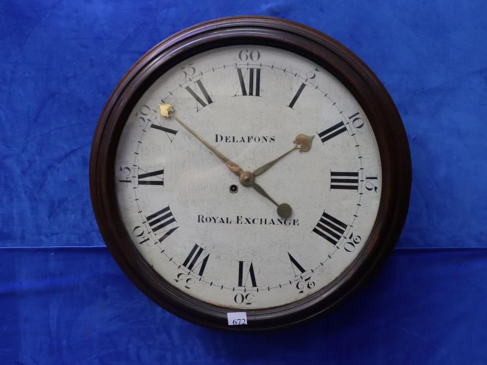 Round wall clock with dark brown rim and white dial, featuring black Roman numerals and black hour markers with gold hands; text reads “DELAfONS” and “ROYAL EXc