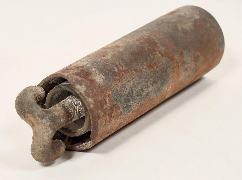 Metal-encased glass insulator with a cylindrical shape and rusted patina, showing a ringed opening at one end.
