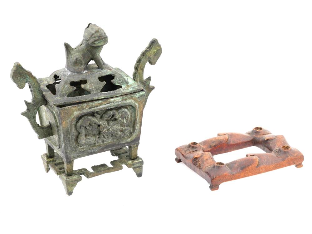 Green patinated metal incense burner on an openwork stand with a perforated panel and stylized handles and finials.