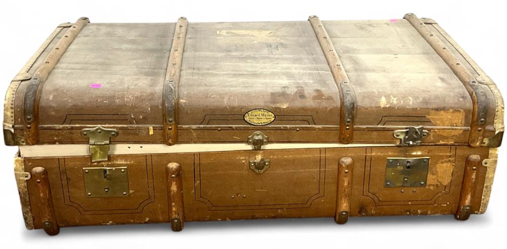 Vintage leather travel steamer trunk with brass corner fittings, metal latch, and a central nameplate on the front.
