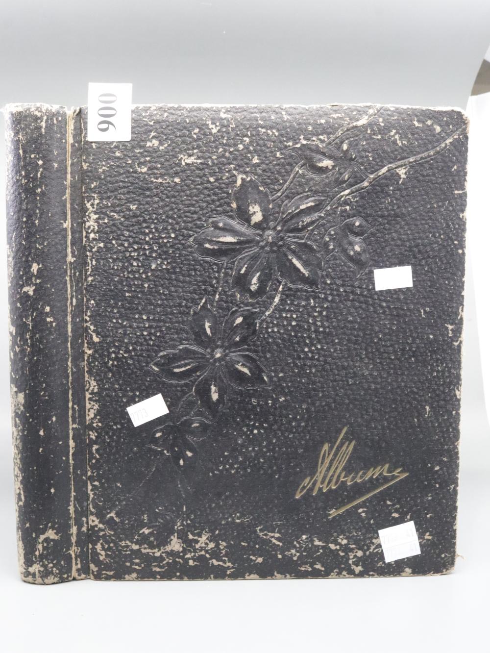 Vintage postcard album with dark textured cover and embossed floral decoration, shown front cover with a handwritten cursive name.