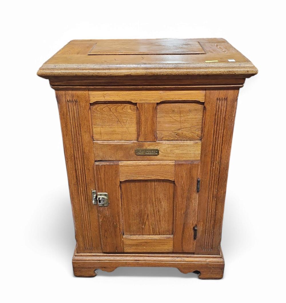 Front view of a wooden ice box with a lift-top lid and two door panels below.