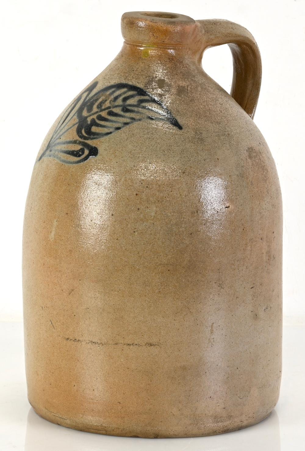 Stoneware jug with a handle and spout, decorated with a blue painted bird and vine-like design on the front.