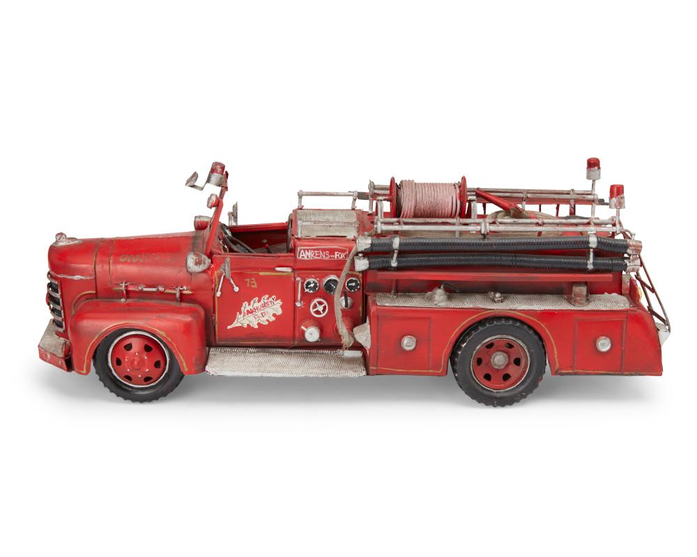 Red vintage fire truck toy with ladder and hose reel, shown in profile on a white background.