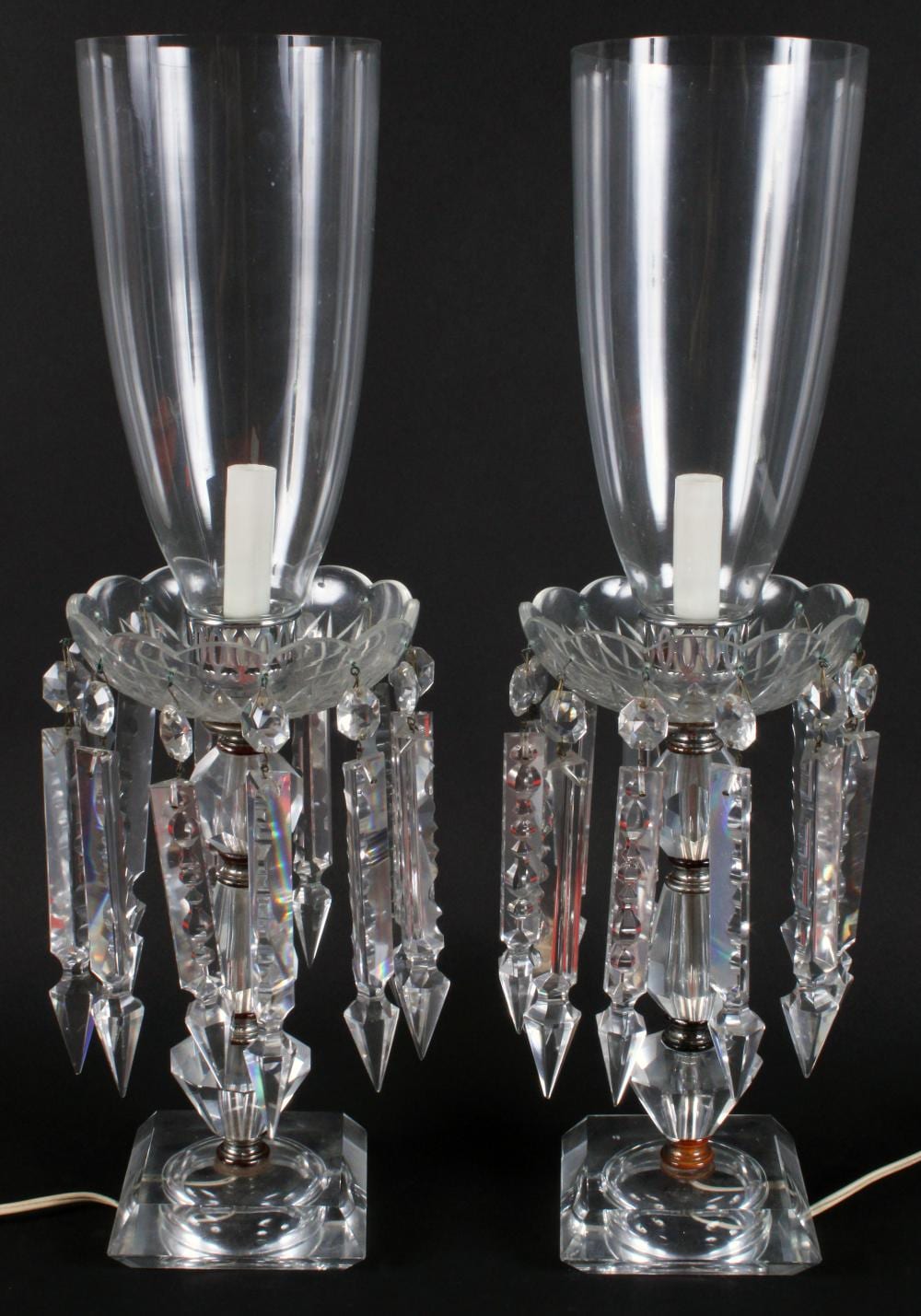 Pair crystal electric hurricane lamps: stacked crystal lamps with large cut bobeches holding large cut glass prism adornments & hurricane shades; 21” T each (Good) sold by Roan Inc. Auctioneers & Appraisers, lot 274 — auction record photograph