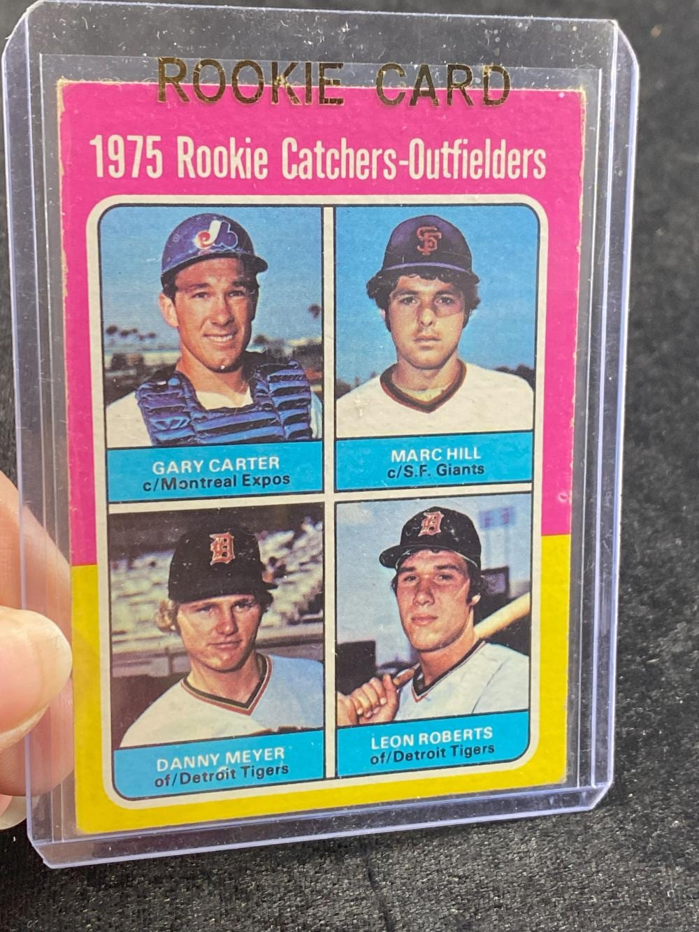Baseball trading card labeled "ROOKIE CARD" showing four player photos with names Gary Carter, Marc Hill, Danny Meyer, and Leon Roberts.