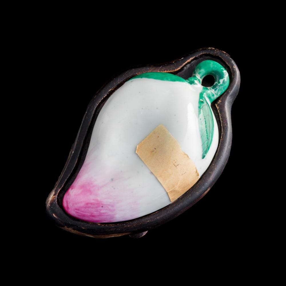 Chinese ceramic washer with a peach-shaped form, white interior with pink and green painted exterior, and a small hole on the handle.