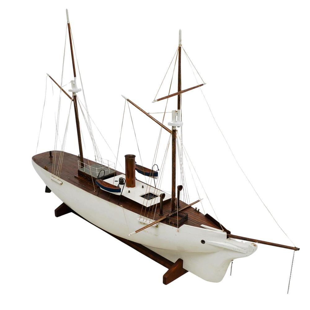 Wood and white antique sailing ship model with multiple masts, rigging lines, and a mounted display stand.