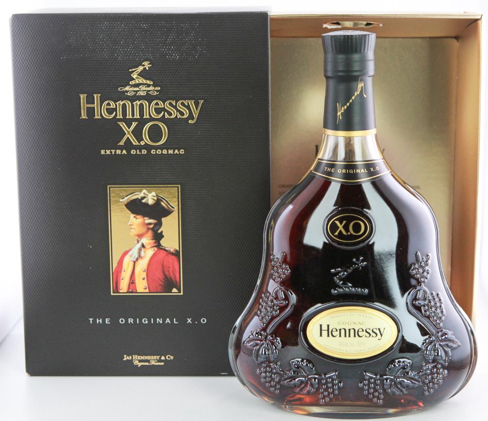 Hennessy X.O extra old cognac bottle with a black presentation box in the background, shown in a product photo.
