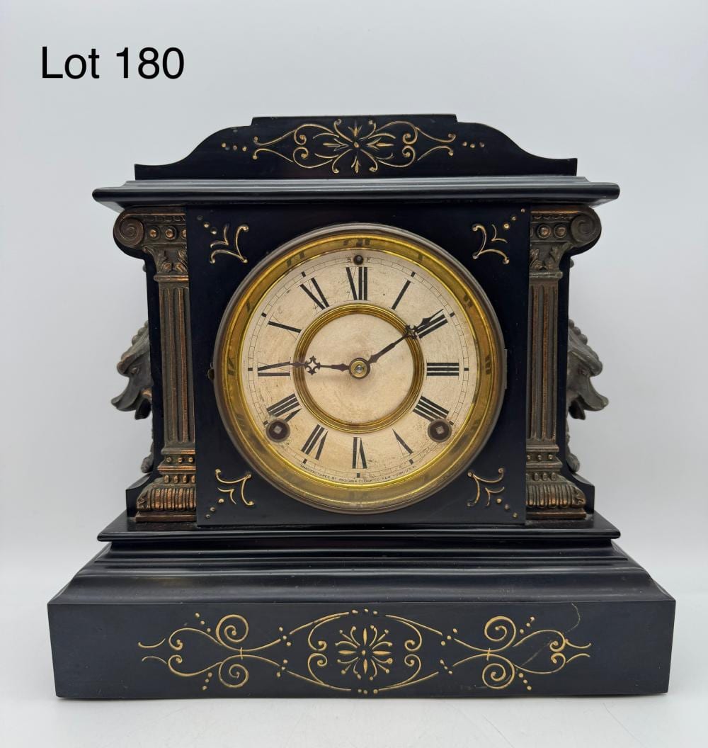 Antique dark blue mantel clock with a round gold-trimmed face, Roman numerals, and ornate gold scrollwork on top and base.