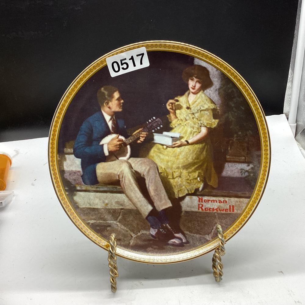 Decorative collector plate featuring an illustration of a seated man playing a guitar and a woman in a yellow dress, with a gold patterned rim.