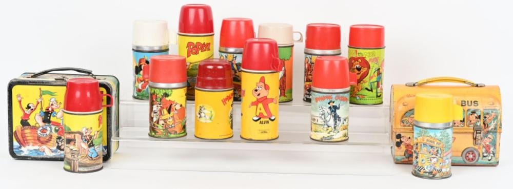 Set of colorful character-themed metal lunchboxes and matching insulated thermos bottles on a white background.