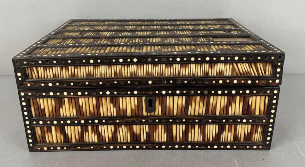 Rectangular inlaid jewelry box with dark wooden sides, gold-toned geometric pattern, and a metal ring pull latch.