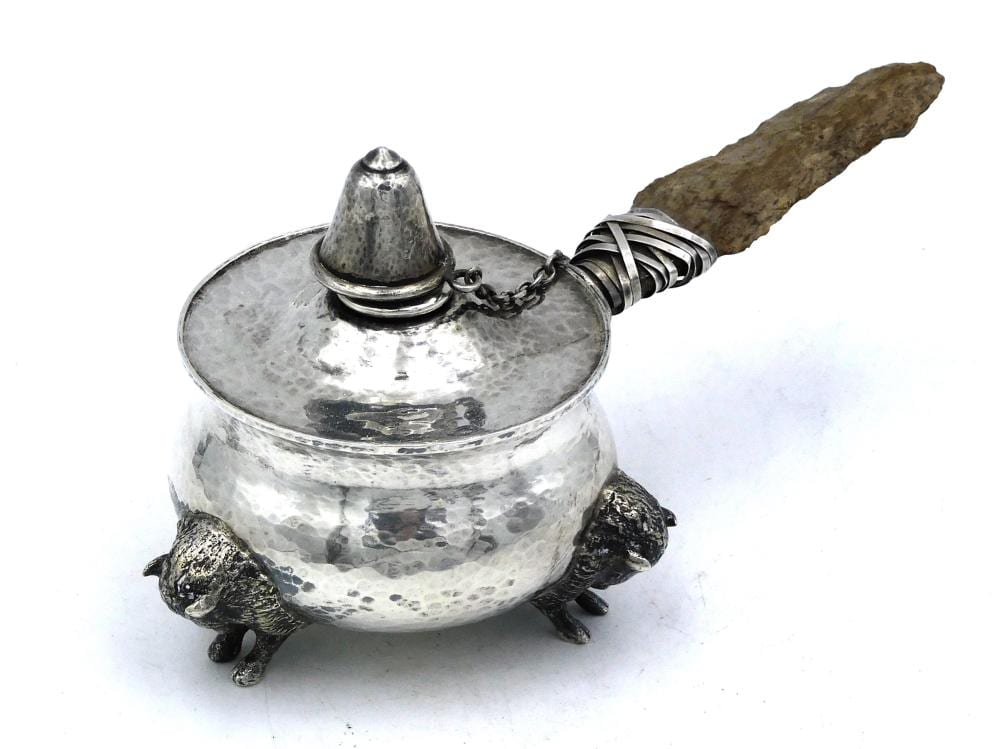 Hammered silver-toned cigar lighter with a domed top and chain, mounted on three lizard-like feet, with a long wooden handle