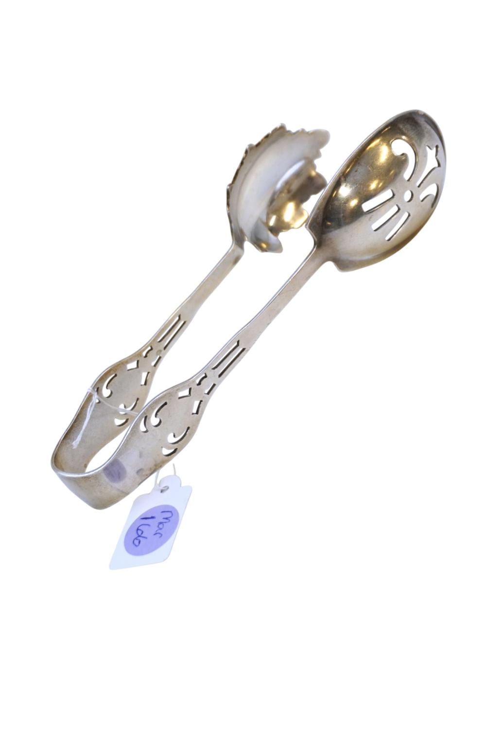 Pair of silver-toned ice tongs with pierced round heads and decorative cutout handles