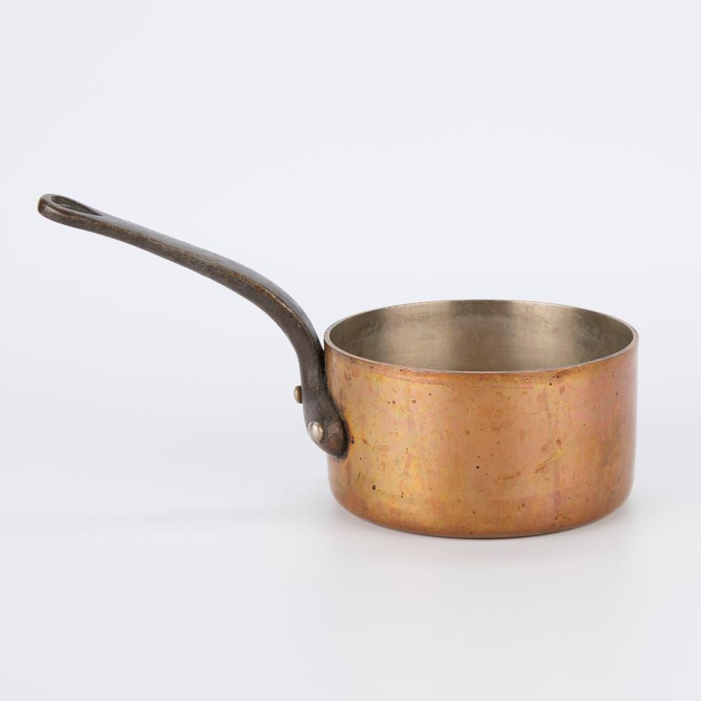 Copper saucepan pot with long handle and small riveted loop detail, interior silver-colored.