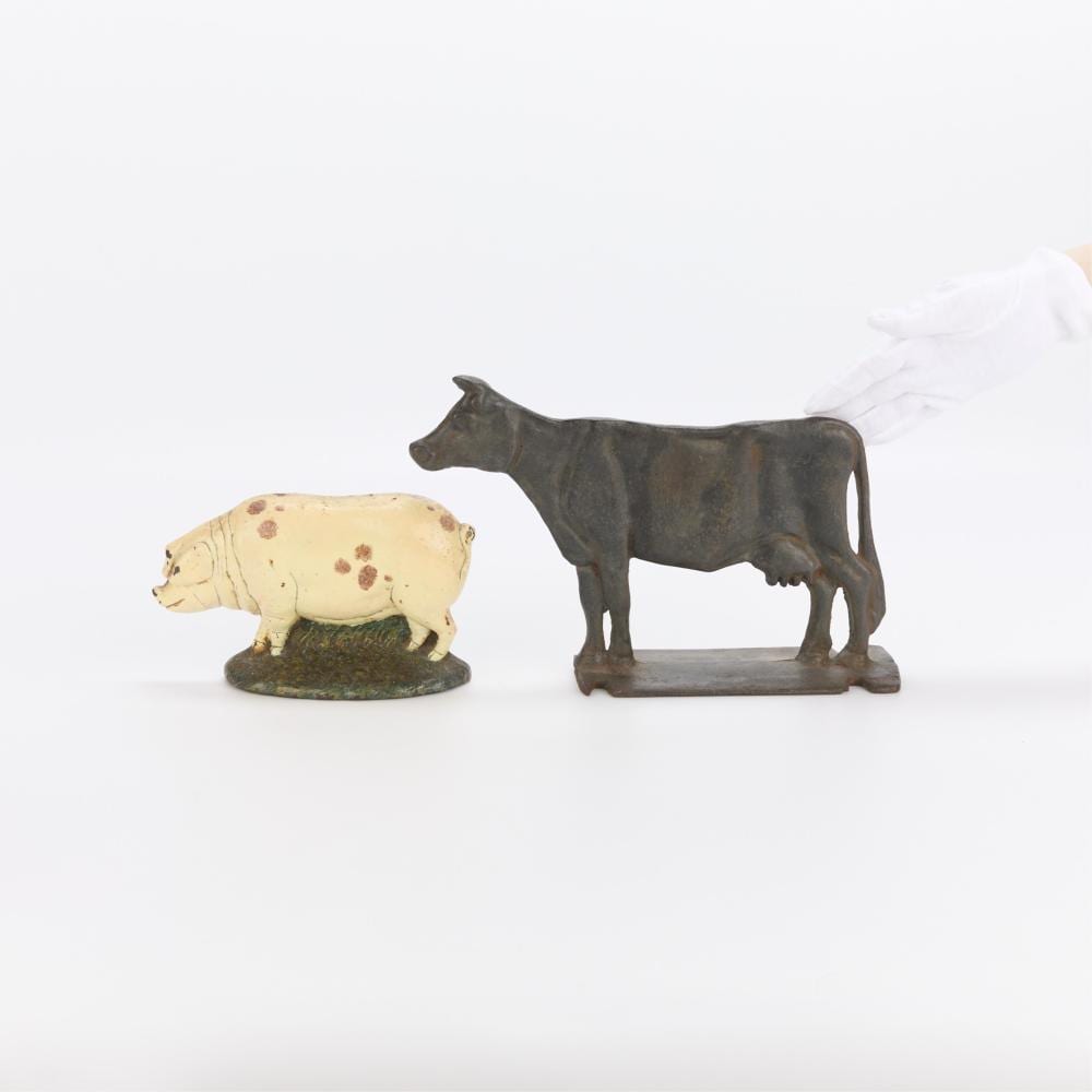 2 Cast-Iron Door Stops - Pig & Cow sold by Revere Auctions, lot 111 — auction record photograph