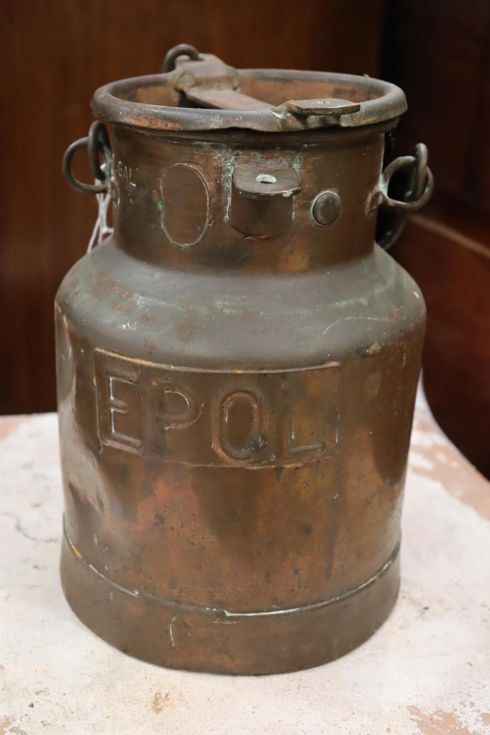 Vintage copper milk can (pail) with side carry handles and embossed lettering on the front, photographed indoors.