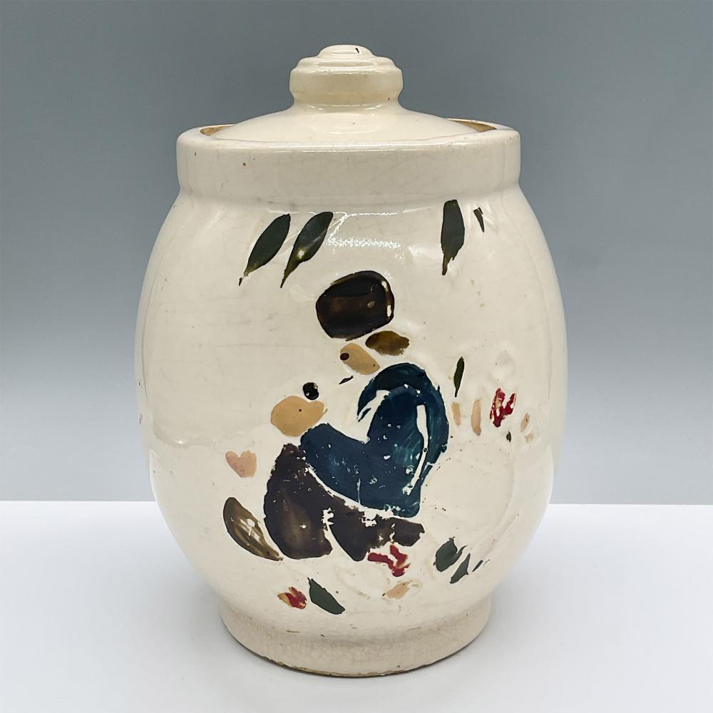White ceramic cookie jar with lid, decorated with a painted blue-haired boy figure and small green, red, and black details.