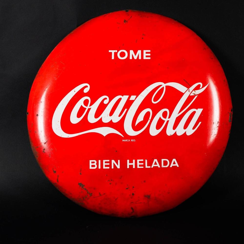Red Coca-Cola button badge with the word “T’OME” at top, “Coca-Cola” script in the center, and “BIEN HELADA” at bottom.
