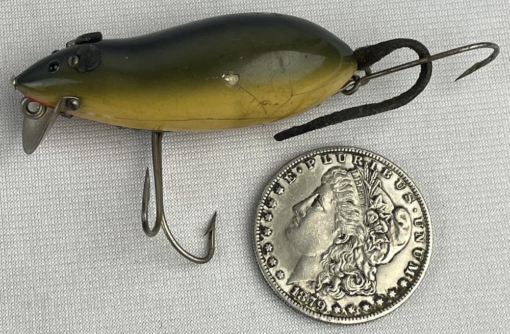 Green and yellow vintage fishing lure with hook hardware next to a silver coin for size reference.