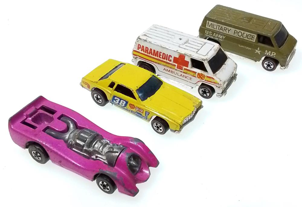 Four small toy die-cast cars in red, yellow, white, and purple, shown on a white background, including an ambulance and military police van.