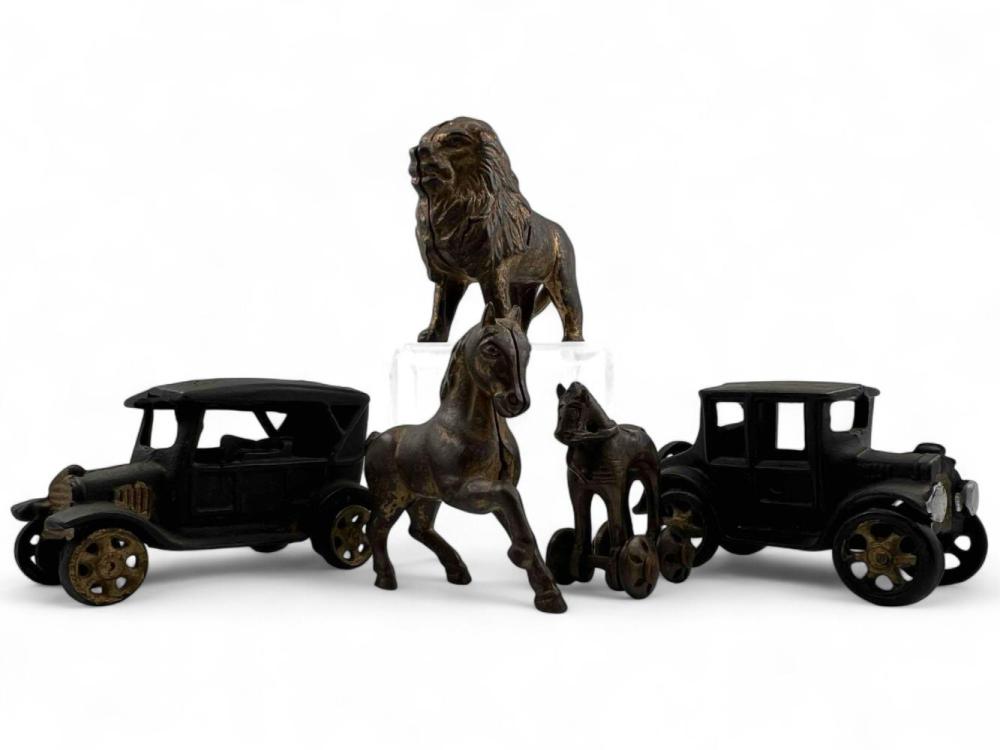 Bronze-colored cast iron dog bank and two cast iron toy cars on a white background.
