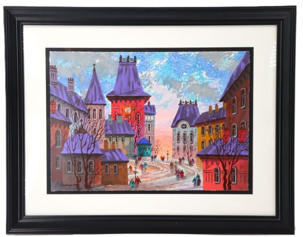 Framed print showing a winter street scene with colorful buildings, snow on the road, leafless trees, and people walking.
