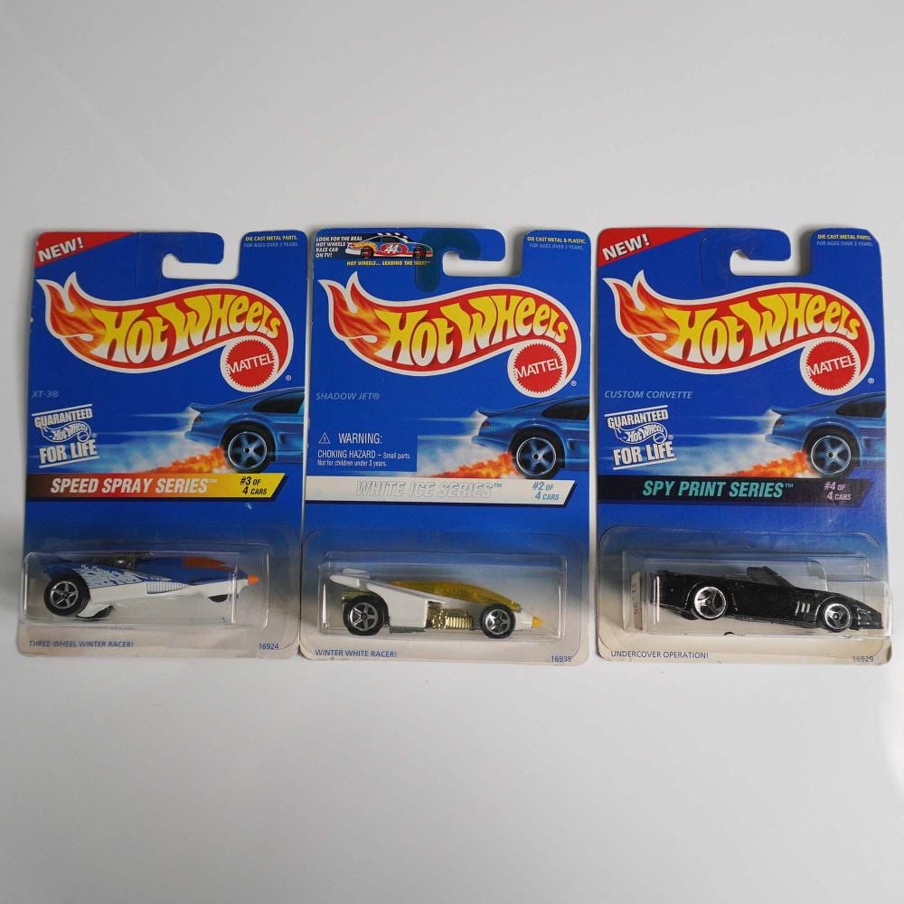 Three Hot Wheels die-cast toy car packages on a white background, each showing a different blue blister-card design with a car inside.