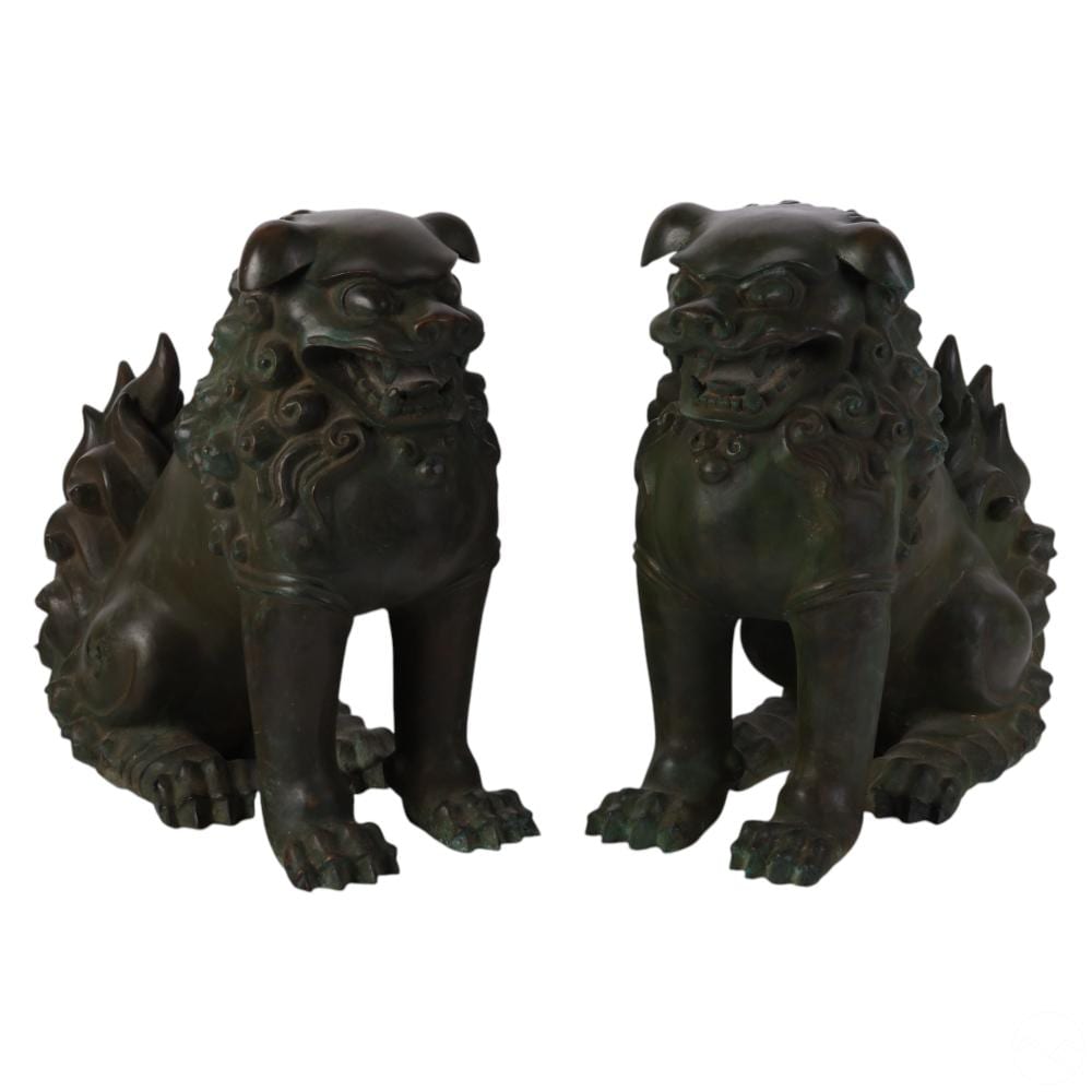 Pair of dark green bronze foo dog guardian lion statues with curled manes, facing outward on a white background.