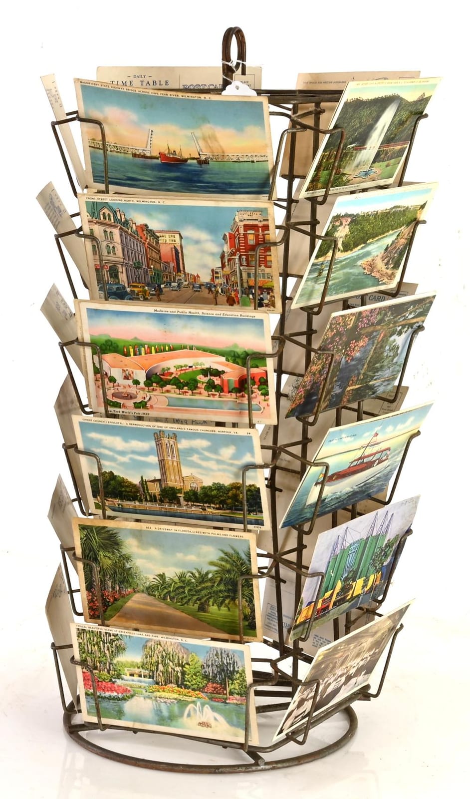 Metal rotating postcard rack holding many illustrated scenic postcards.