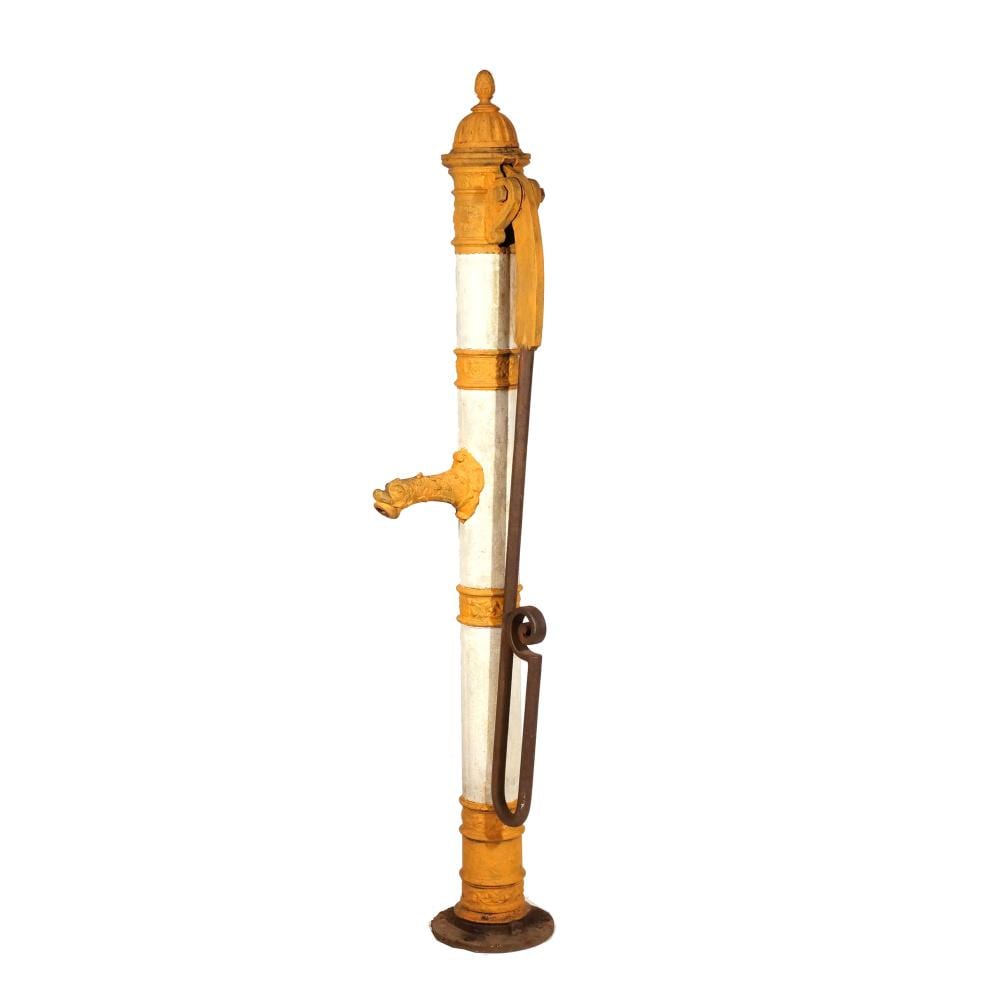Antique-style hand water pump with a tall column, ornate cap, and a curved metal handle, shown against a white background.
