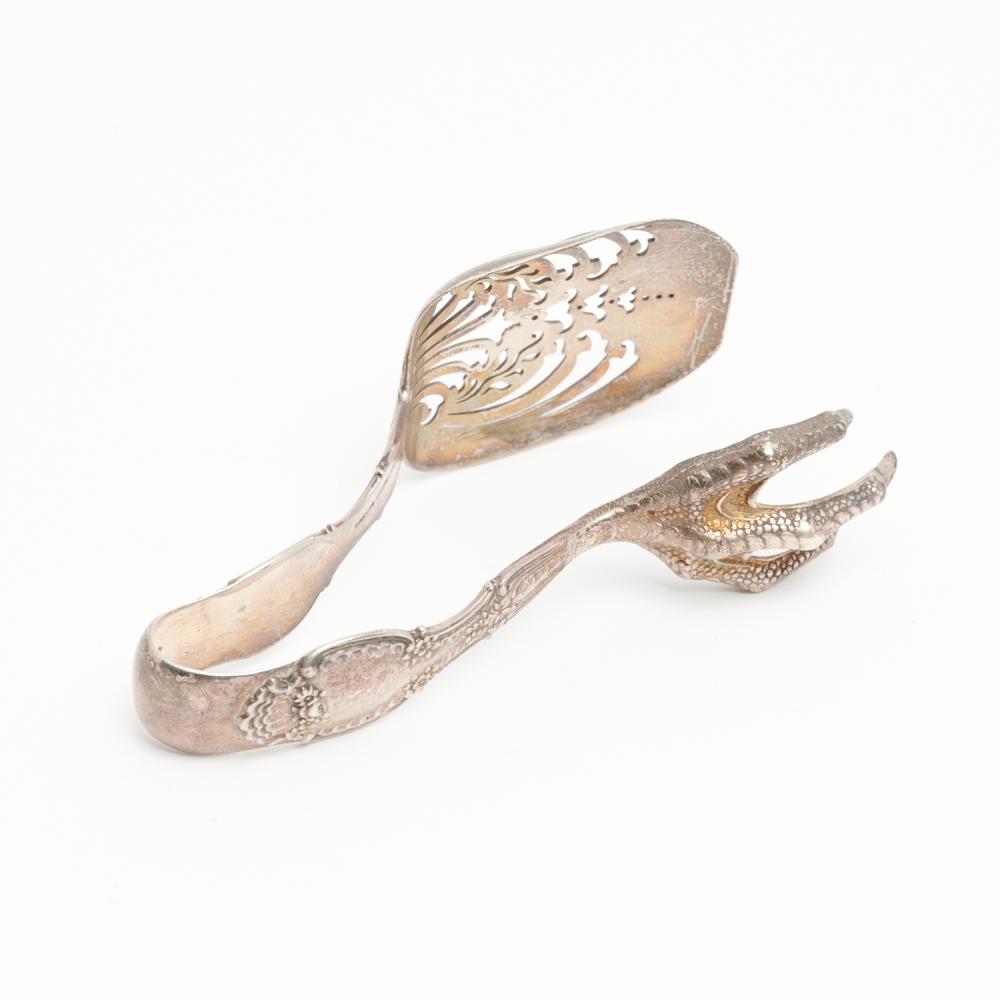 Pair of ornate silver ice tongs with engraved panels and a bird-shaped handle end, photographed on a white background.