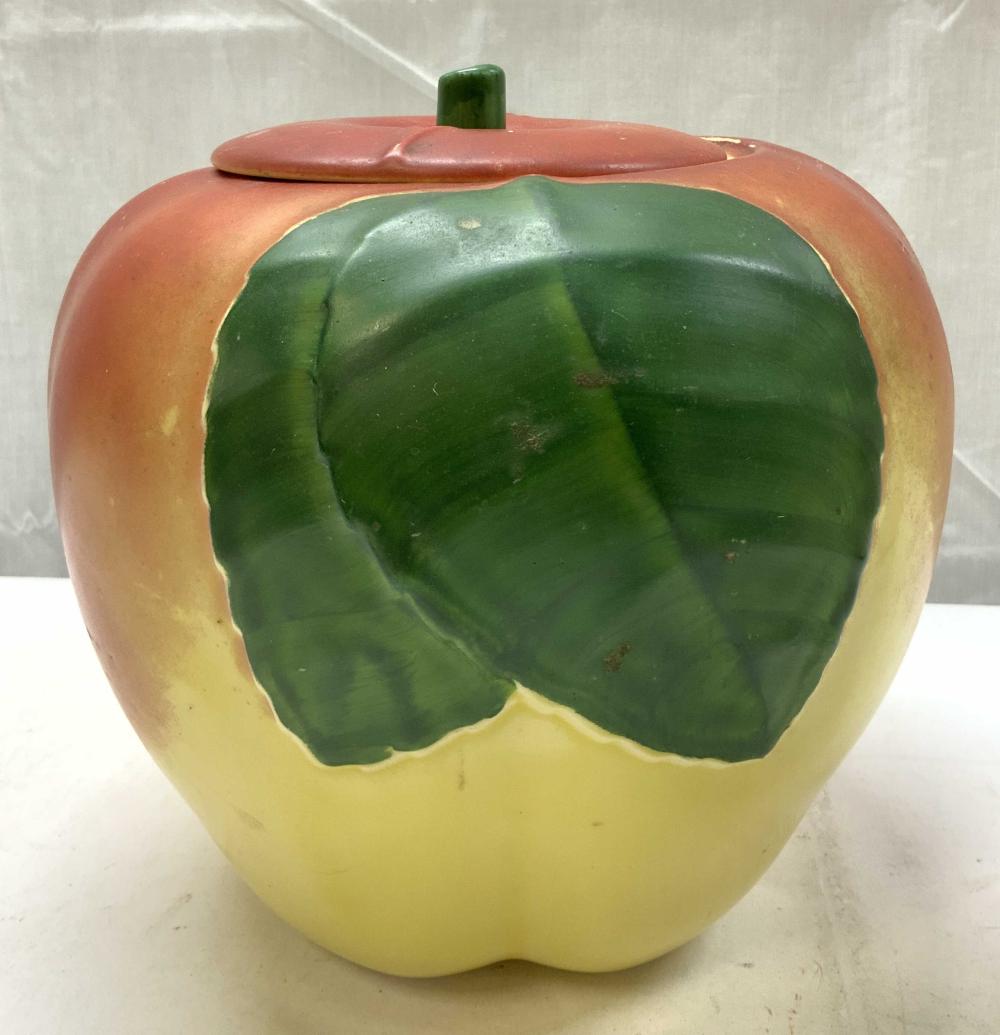 Ceramic cookie jar shaped like a red apple with a green stem and a green interior panel on the front.