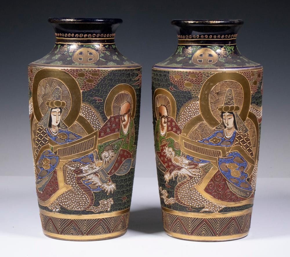 Pair of tall decorative ceramic vases with gold borders and painted figures in robes, against a blue floral-patterned ground.